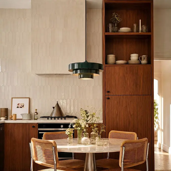 Lindby Pendelleuchte Tivra - grün, dunkelGrün, E27 - Eine dunkelgrüne Hängelampe mit Stufen hängt über einem Marmor-Esstisch mit Rattan-Stühlen in einer modernen Küche und spendet Licht.