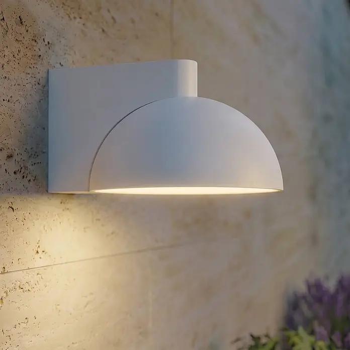 Lucande Außenwandleuchte Velira - alu / grau / zink, alu / grau / zink, IP54 - Weiße, kuppelförmige Wandleuchte strahlt warmes Licht nach unten auf eine strukturierte Wand.