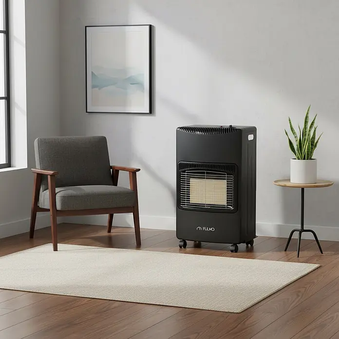 Fulmo Estufa de gas infrarrojos plegable Winter - Gas butano, Negro - Un calentador de gas portátil negro con elemento visible y ruedas, mostrado en una acogedora sala de estar junto a un sillón.
