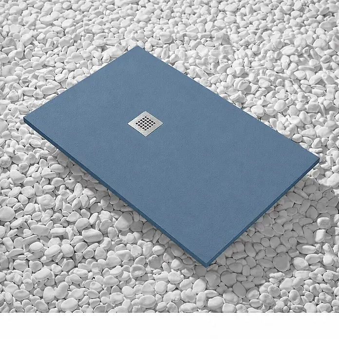 FRASCIO New Tecnology Duschwanne Vulcano Line Slim - L x B: 175 x 100 cm, Verbundwerkstoff, Taubenblau RAL 5014 - Blaue rechteckige Duschwanne mit strukturierter Oberfläche und quadratischem Metallablauf, auf weißen Kieselsteinen.