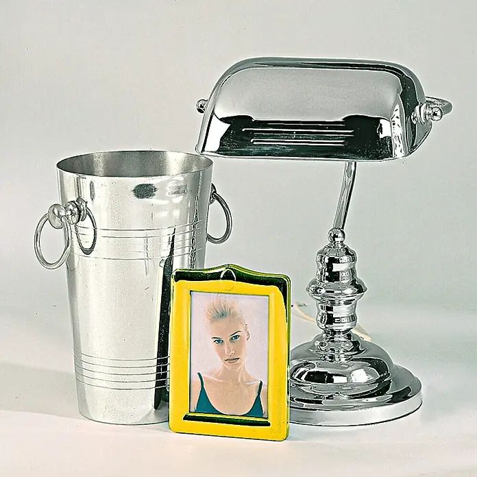 Dupli-Color Effect Spezial-Lackspray Chrome Silver - Chrom, Glänzend, 400 ml - Stillleben mit einem Champagnerkühler aus Metall, einem Bilderrahmen mit einem Porträt und einer Schreibtischlampe im Banker-Stil.