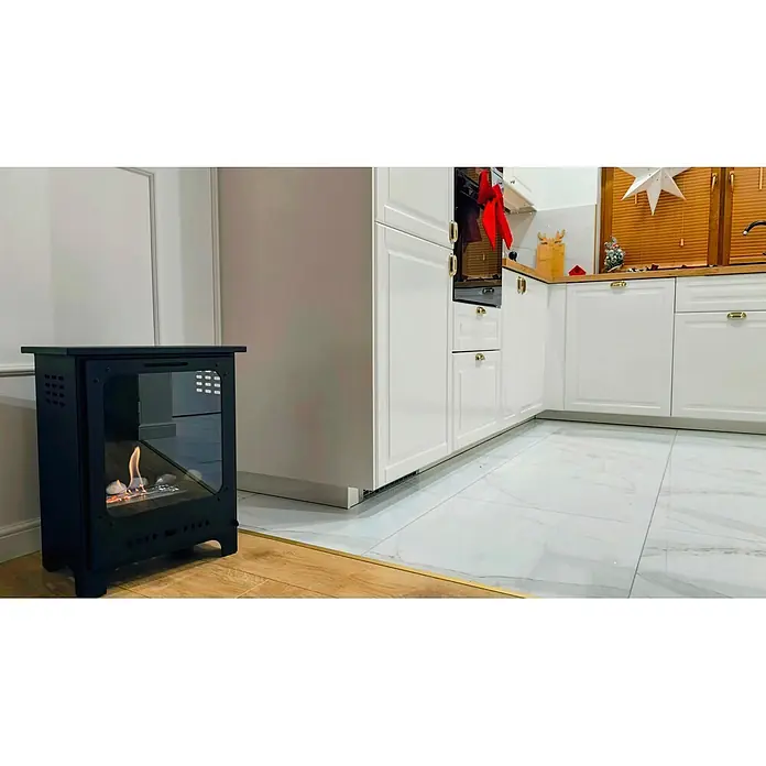 Bysil Kaminofen - Material Verkleidung: Stahl, Schwarz - Schwarzer Metall-Bioethanolkamin mit Glasscheiben und lodernden Flammen, auf Holzboden in einer modernen weißen Küche platziert.