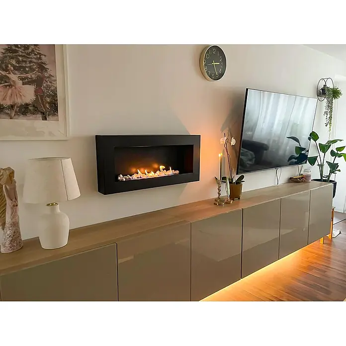 Bysil Kaminofen - Material Verkleidung: Stahl - Modernes Wohnzimmer: lange schwebende Medienkonsole mit glänzenden taupefarbenen Türen und Unterbauleuchten, darüber schwarzer Wandkamin.