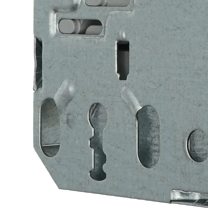 Bever Einsteckschloss mit Magnetfalle - Buntbartschlüssel, Dornmaß: 55 mm, Links, Stulpbreite: 20 mm, Stulpform: Rund - Nahaufnahme einer verzinkten Metallhalterung mit verschiedenen Befestigungslöchern, inklusive Langloch- und Schlüssellochausschnitten.