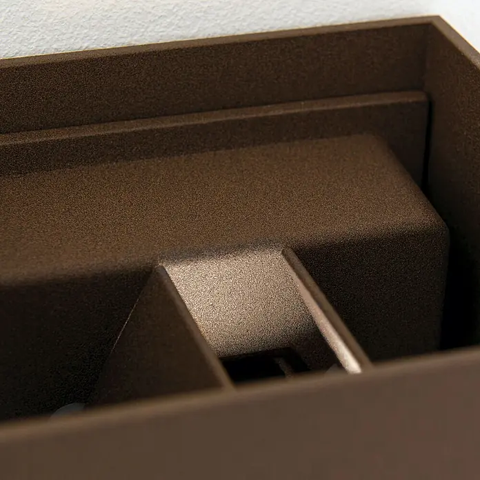 Orion Leuchten LED-Sensor-Außenwandleuchte Cube - 13 W, L x B x H: 10 x 10 x 10 cm, Corten, Klar, Warmweiß - Nahaufnahme einer bronzebraunen, strukturierten Innenwandleuchte mit gestufter, architektonischer Form.