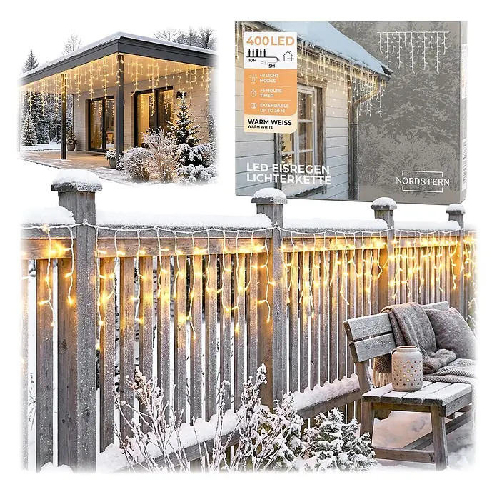 Nordstern LED-Lichterkette Eisregen Verlängerung - Außen, Lichtfarbe: Warmweiß, Anzahl Leuchtmittel: 400 Stk., Netzbetrieben - Warmweiße LED-Eisregen-Lichterkette schmückt verschneites Haus und Zaun und zeigt ihre Verwendung als winterliche Außenbeleuchtung.