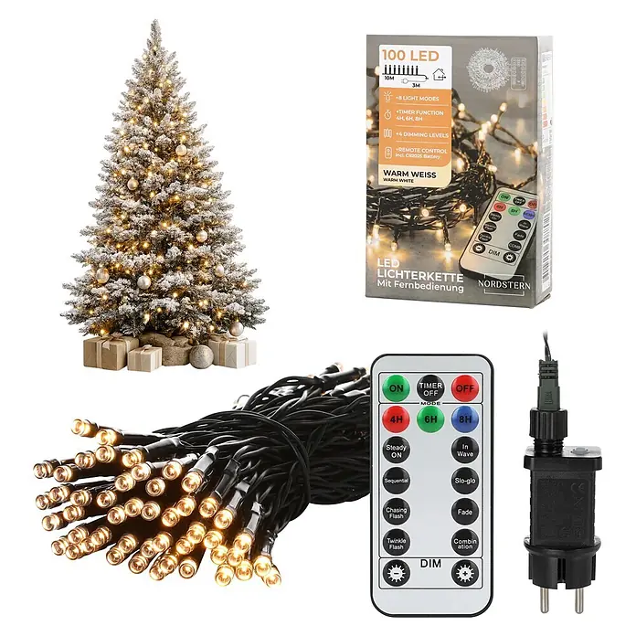 Nordstern LED-Lichterkette - Außen, Lichtfarbe: Warmweiß, Anzahl Leuchtmittel: 100 Stk., Netzbetrieben - Warmweiße LED Lichterkette (100 LEDs) mit Fernbedienung, Netzteil und Verpackung, präsentiert mit geschmücktem Weihnachtsbaum.