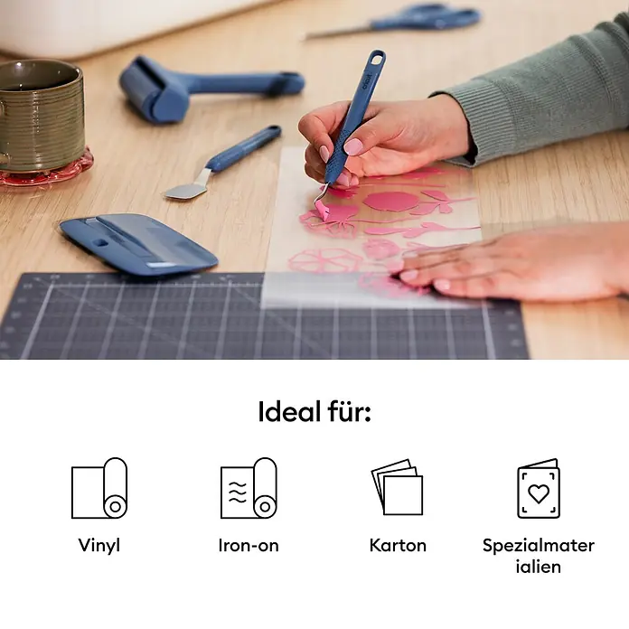 Cricut Plotter-Werkzeug Entgitterhaken - Geeignet für: Aufkleber, Blau - Eine Person benutzt ein blaues Cricut-Entgitterwerkzeug, um überschüssiges rosa Vinyl von einem Design zu entfernen.