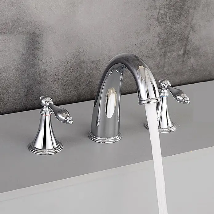 Hudor Badewannenarmatur 3 -  - Glänzende Chrom-Drei-Loch-Armatur mit zwei Griffen und hohem Auslauf, installiert und aktiv Wasser in ein Waschbecken spendend.