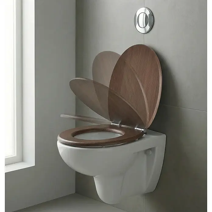 SAINOS WC-Sitz MDF WC-Sitz, Braun Holzoptik, Universal-O-Form, Absenkautomatik, Unten - MDF, Braun, Mit Absenkautomatik - Wandhängendes WC mit dunklem Holz-Soft-Close-Sitz und -Deckel in Bewegung, neben einer Chrom-Spülplatte.