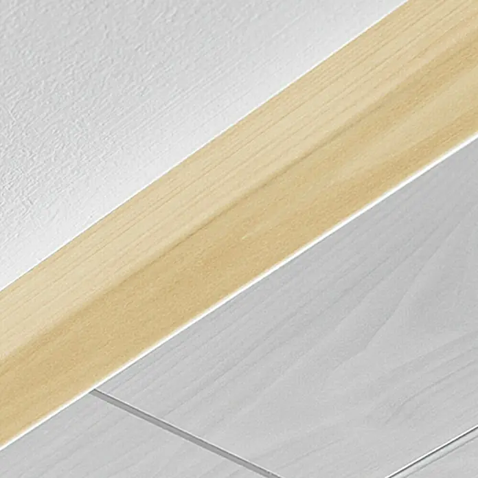 LOGOCLIC Winkelleiste Ahorn - 260 cm x 35 mm x 35 mm, MDF - Nahaufnahme einer hellen Holzbodenleiste, die Wand und Boden elegant verbindet. Die Leiste sorgt für einen sauberen und stilvollen Übergang im Raum.