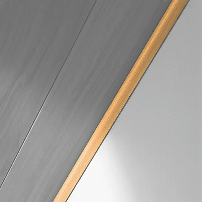 LOGOCLIC Abdeckleiste Buche - 260 cm x 25 mm x 6 mm - Nahaufnahme einer grauen Holzpaneele mit einer hellbraunen Holzleiste, die an einer weißen Wand befestigt ist. Minimalistisch und modern.