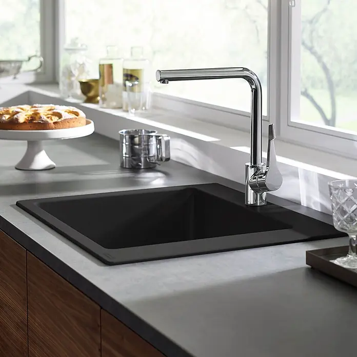 Hansgrohe Einbauspüle S51 - 56 x 51 cm, Graphitschwarz - Schwarzes Küchenspülbecken und Chromarmatur in einer grauen Arbeitsplatte, mit Küchenzubehör.