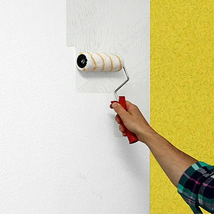 Lehnartz Kleisterroller Roll-On Vlies Plus - Breite Rolle: 180 mm - Farbroller beim Auftragen von weißer Farbe auf eine Wand.