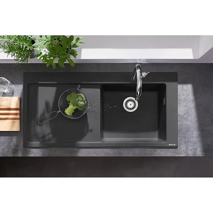 Hansgrohe Einbauspüle S51 - 105 x 51 cm, Graphiteschwarz, Position Ablage: Links - Dunkelgraue Verbundstoff-Küchenspüle mit Abtropffläche und Becken, mit Chromarmatur und Brokkoli.