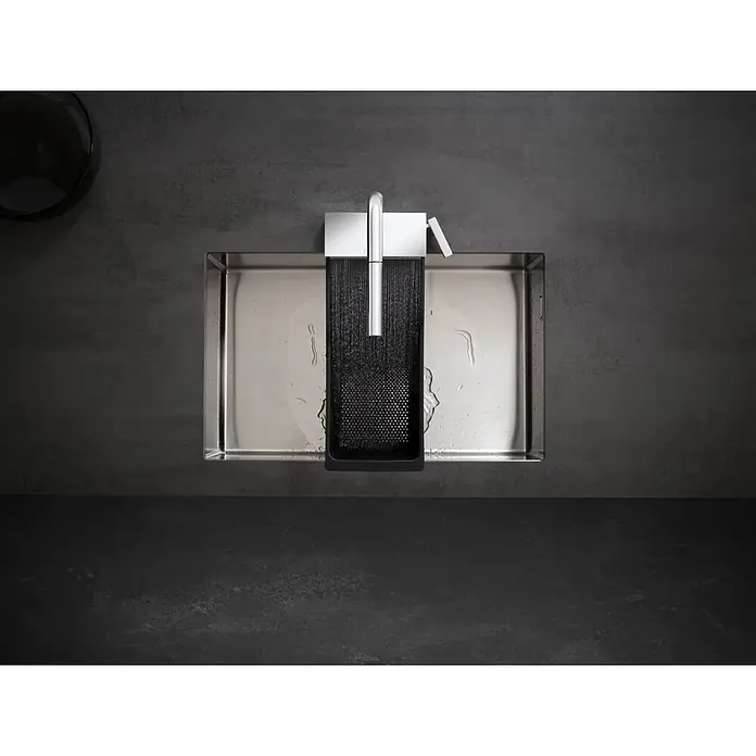 Hansgrohe Siebgitter - Passend für: S51 SilicaTec Spülen und S71 Edelstahlspülen, Kunststoff, Schwarz - Blick von oben auf eine moderne Edelstahlspüle mit Chromarmatur. Wasser fließt in eine schwarze Texturablage auf einer dunkelgrauen Arbeitsplatte.