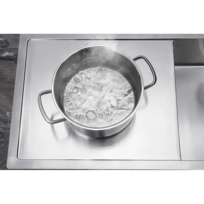 Hansgrohe Einbauspüle S715 - 104,5 x 51 cm, Edelstahl - Kochendes Wasser in einem Edelstahltopf auf einer modernen Küchenarbeitsplatte mit integrierter Spüle.