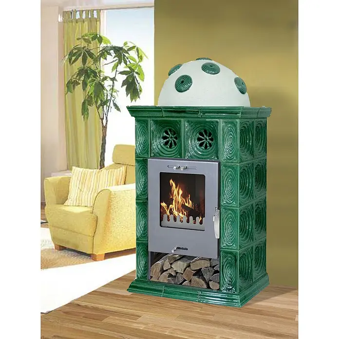 Domofire Kaminofen Innsbruck II - 7 kW, Raumheizvermögen: 140 m³, Grün - Grüner Kachelofen mit brennendem Feuer, Holzfach und weißer Deko-Haube im Wohnzimmer.