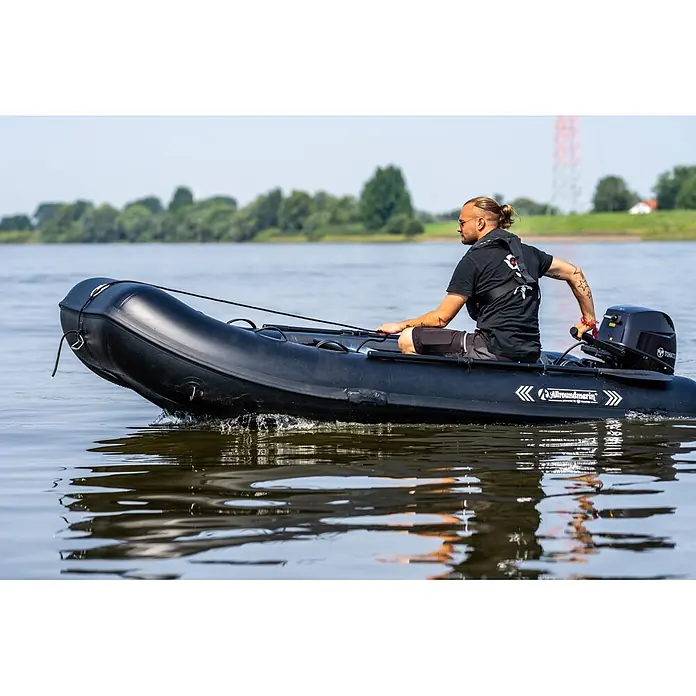 Tohatsu Schlauchboot-Set MFS 5 DDS Motor & Allroundmarin T320 Schlauchboot - Motorleistung: 3,7 kW - Person fährt schwarzes Allroundmarin Schlauchboot mit Tohatsu Außenbordmotor auf dem Wasser.
