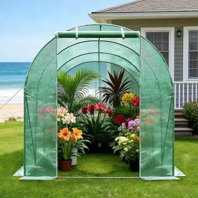 SONNENH Gewächshaus - 200 x 300 cm, Material Seitenwand: Kunststoff, Grün - Grünes, begehbares Bogengewächshaus mit bunten Topfpflanzen auf einem Rasen am Strand und Haus.