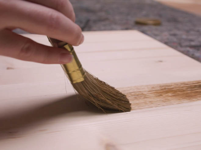 Holzplatte wird mit Wachs bestrichen