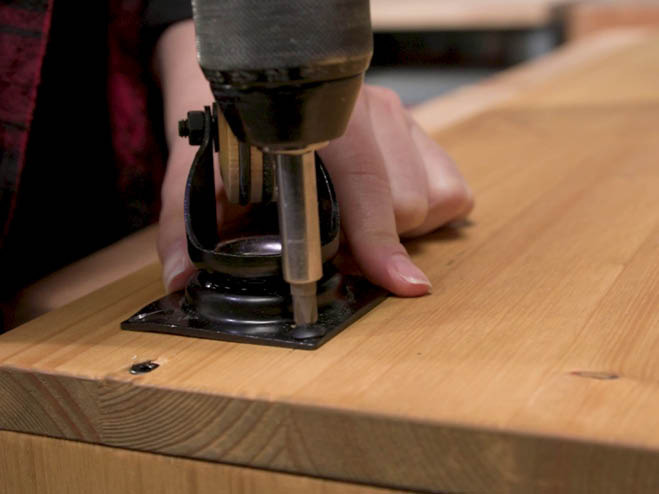 Rollen werden an die Holzplatte geschraubt