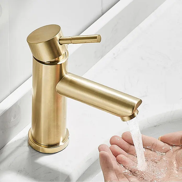 Hudor Waschtischarmatur 002 -  - Gebürsteter goldener Badarmatur spendet Wasser in geschöpfte Hände im weißen Waschbecken.
