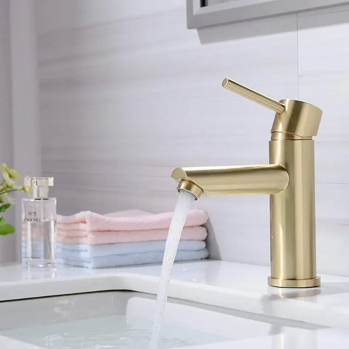 Hudor Waschtischarmatur 002 -  - Gebürsteter goldener Badarmatur mit fließendem Wasser in ein weißes Waschbecken, Teil einer modernen Badezimmerausstattung.