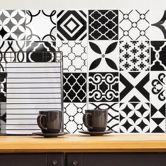 Smart Tiles Selbstklebemosaik Vintage - 22,86 x 22,86 cm, Bilbao, Glänzend - Zwei dunkelgraue Keramiktassen mit Untertassen auf einer Holztheke, bereit für Kaffee oder Tee.