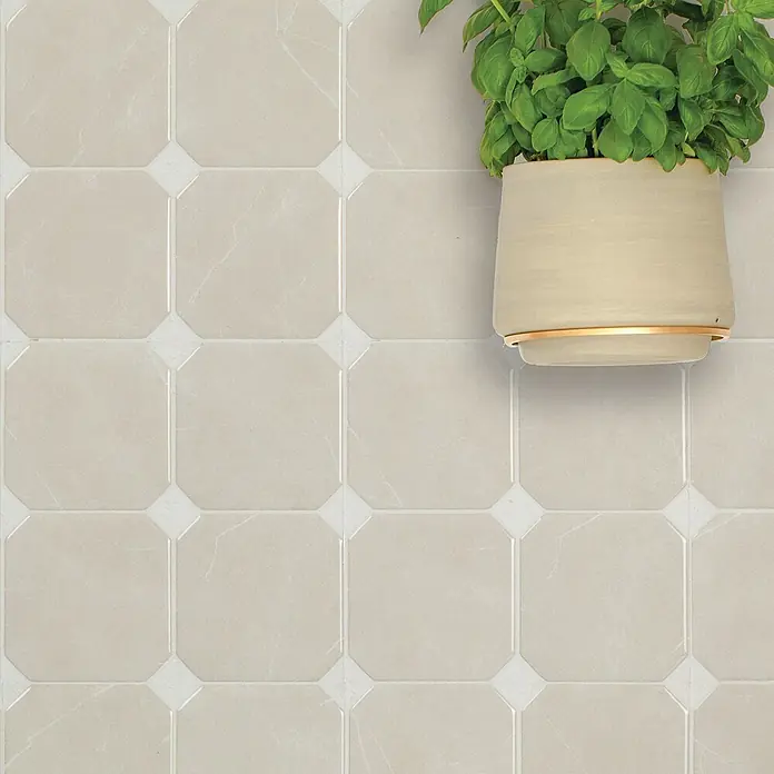 Smart Tiles Selbstklebemosaik Betera - 19,69 x 19,69 cm, Beige, Matt - Beige achteckige Fliesen mit weißen Quadrateinsätzen an der Wand, mit einer grünen Pflanze in beigem Topf.