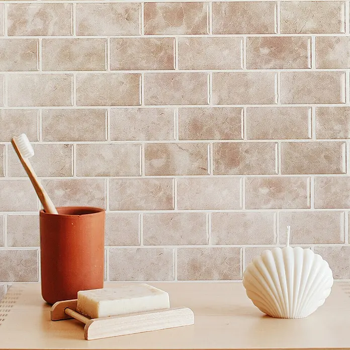 Smart Tiles Selbstklebemosaik Subway - 27,81 x 24,64 cm, Sora, Glänzend - Natürliche Badezimmer-Essentials: Terrakotta-Becher mit Zahnbürste, Holzseifenschale mit Seife, weiße Muschelkerze.