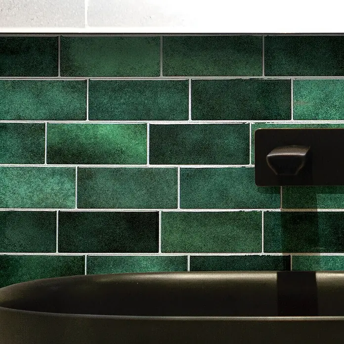 Smart Tiles Selbstklebemosaik Metro - 29,34 x 21,28 cm, Fiona, Glänzend - Glänzende dunkelgrüne Metrofliesen an einer Wand, passend zu schwarzem Waschbecken und Wasserhahn.