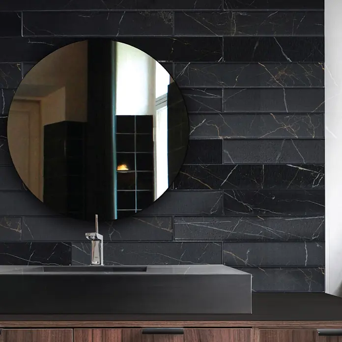 Smart Tiles Selbstklebemosaik Norway - 57,31 x 49,4 cm, Dorato, Matt - Schwarze U-Bahn-Fliesen in Marmoroptik mit Gold- und weißen Adern bilden eine dramatische Badwand hinter einem dunklen Waschtisch und Spiegel.