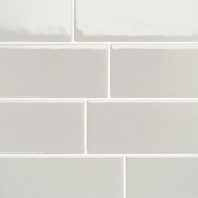 Smart Tiles Selbstklebemosaik Metro - 29,34 x 21,28 cm, Cassandra, Glänzend - Glänzende hellgraue Keramik-Subway-Fliesen mit weißen Fugen.