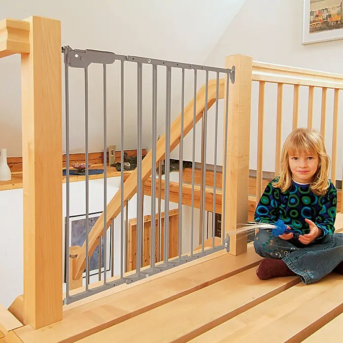 Star Stairs Sicherheitsgitter Lars - Höhe: 68 cm, 74,4 cm - 113 cm - Ein graues Treppenschutzgitter aus Metall ist an einem Treppenabsatz installiert, um die Sicherheit des Kindes zu gewährleisten.