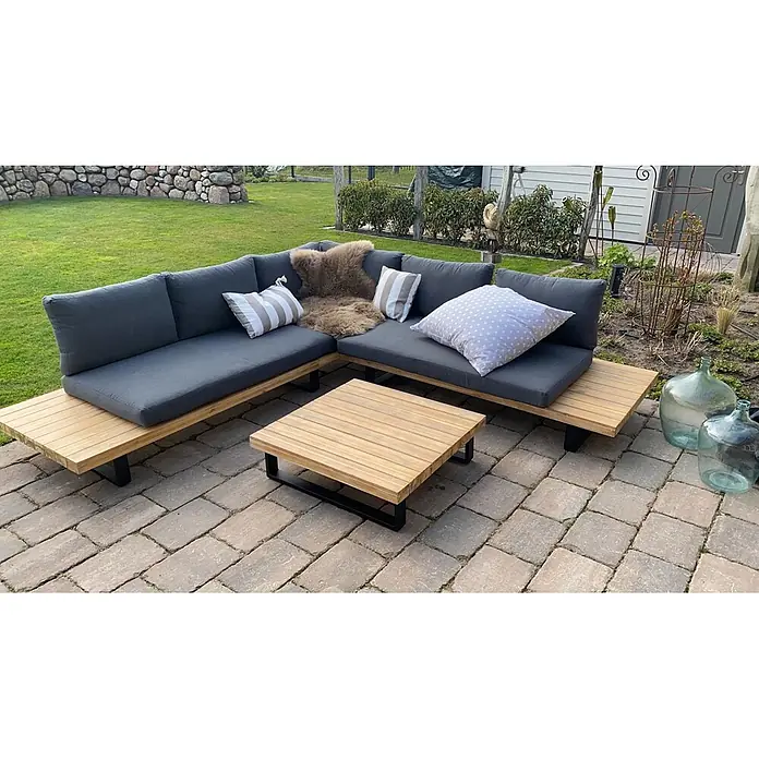 Garten-Garnitur | Garnitur Sitzgruppe Lounge-Set | Spun Poly Akazie Holz FSC® Alu | Hellbraun | Polster Dunkelgrau -  - Outdoor-Ecksofa aus Holz mit dunkelgrauen Kissen und passendem Couchtisch auf gepflasterter Terrasse.