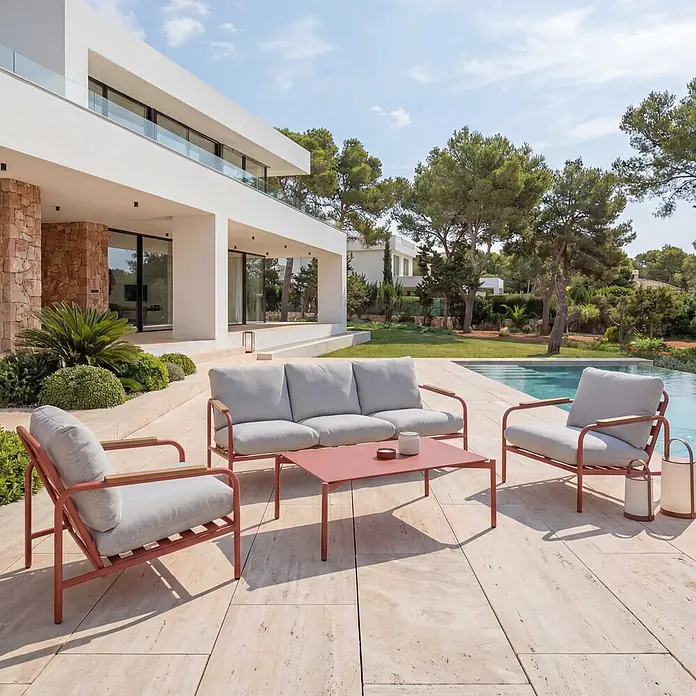 Mendler Alu-Gartengarnitur HWC-O11 3-Sitzer - terrakotta Polster beige -  - Outdoor-Lounge-Set mit rotbraunen Gestellen, hellgrauen Kissen und Holzarmlehnen auf einer Terrasse am Pool.
