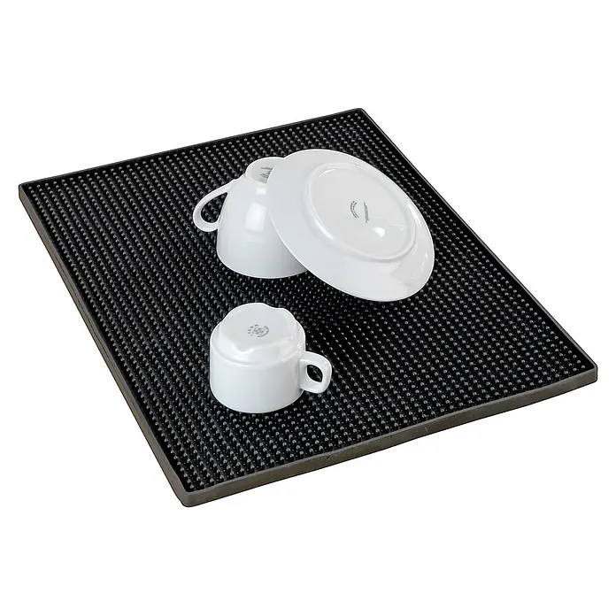 Wenko Abtropfmatte Maxi - 400 x 300 mm, Schwarz - Schwarze Gummi-Abtropfmatte mit Noppenoberfläche, darauf zwei weiße Tassen und ein Teller.