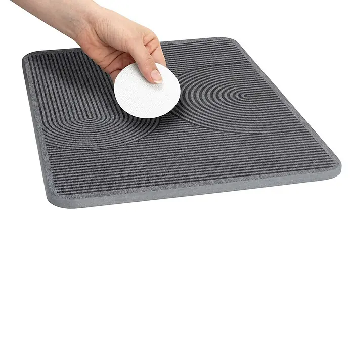 Wenko Abtropfmatte - 410 x 20 mm, Grau - Hand hält einen weißen runden Untersetzer über einer grauen rechteckigen Matte mit Streifenmuster.