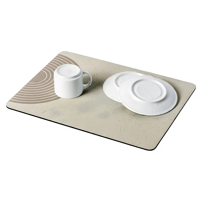 Wenko Abtropfmatte Dima - 60 x 60 mm, Beige - Beige Geschirrabtropfmatte mit Kreismuster, schwarzem Rand und Wassertropfen, mit einer weißen Tasse und drei Tellern.