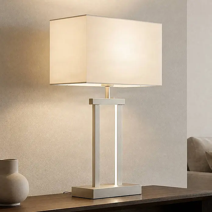 Lindby LED Tischlampe dimmbar, Tischleuchte Stoffschirm weiß -  - Moderne Tischlampe mit gebürstetem Metallsockel, rechteckigem Stoffschirm und integriertem Licht auf einer Holzoberfläche.