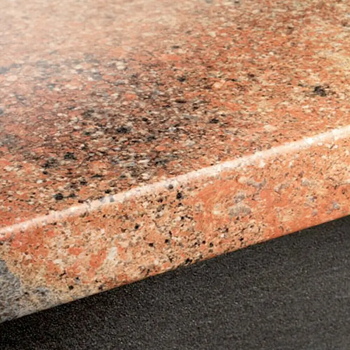 Resopal Premium Encimera de cocina al corte - Granito Zaragoza, Espesor: 3,8 cm, Ancho: 60 cm - Primer plano de una losa de granito pulido con motas rojas y negras. La superficie es lisa y reflectante.