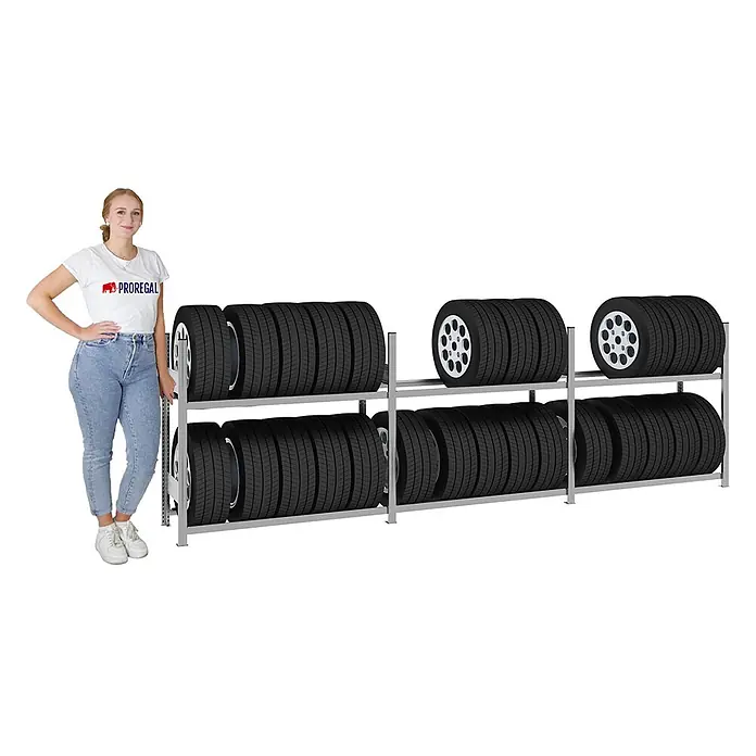 Proregal Reifenregal TIRE PRO - H x B x T: 115 x 390 x 43 cm, Stecken, Verzinkt - Zweistufiges Reifenlagerregal aus grauem Metall, gefüllt mit Autoreifen. Eine Frau steht daneben als Größenvergleich.