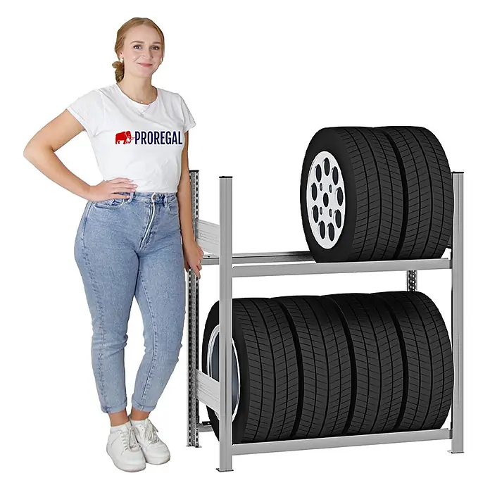 Proregal Reifenregal TIRE PRO - H x B x T: 115 x 100 x 43 cm, Stecken, Verzinkt - Silbernes Metall-Reifenlagerregal mit zwei Ebenen, bestückt mit mehreren Reifen, und einer Person zur Größenreferenz.