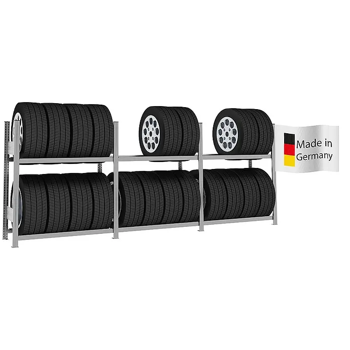 Proregal Reifenregal TIRE PRO - H x B x T: 115 x 300 x 43 cm, Stecken, Verzinkt - Metallisches Reifenlagerregal mit mehreren Autoreifen, teilweise mit silbernen Felgen, und einer „Made in Germany“-Flagge.
