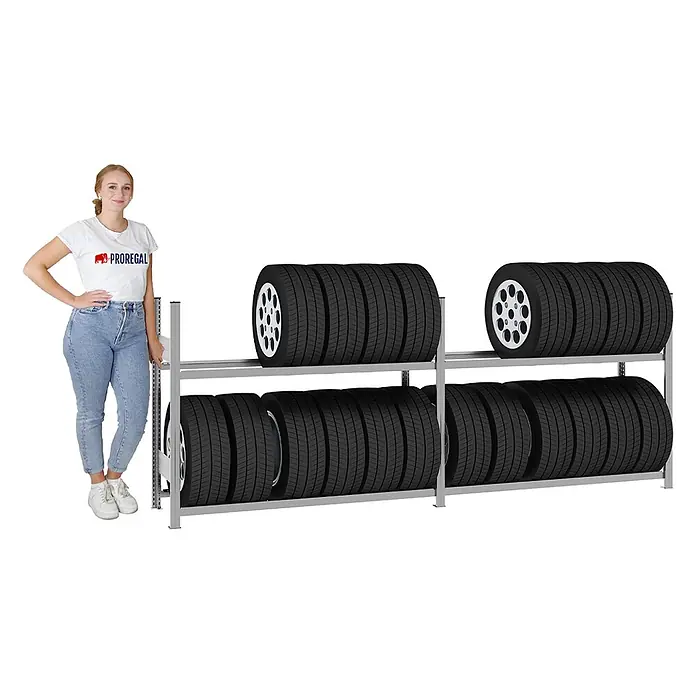 Proregal Reifenregal TIRE PRO 100cm Feldbreite - H x B x T: 115 x 300 x 43 cm, Stecken, Verzinkt - Graues Metall-Reifenregal mit zwei Ebenen, gefüllt mit Autoreifen, und einer Frau daneben zur Größenreferenz.