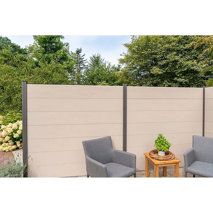GartenLand Steckzaun-Element WPC Zaun Ameland Ohne Pfosten Ohne Abschlussleiste - B x H: 180 x 180 cm, Sand-Multicolor, Verbundwerkstoff - Heller, beiger Sichtschutzzaun mit dunkelgrauen Pfosten, der eine private Terrasse mit Stühlen und Tisch umschließt.