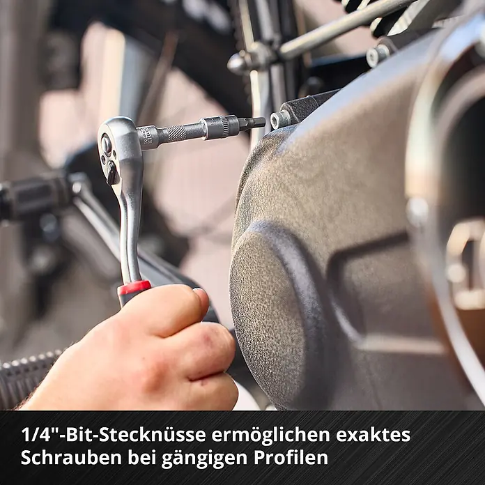 Einhell Werkzeugkoffer E-Case KFZ - 121 -tlg. - Eine Person zieht mit einer Ratsche und 1/4"-Bit-Stecknuss eine Schraube an einem Motorteil fest.