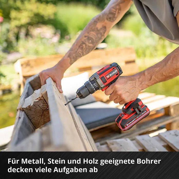 Einhell Werkzeugkoffer E-Case Renovierung - 78 -tlg. - Eine Person bohrt mit einem rot-schwarzen Einhell Akku-Bohrschrauber in ein Holzbrett.