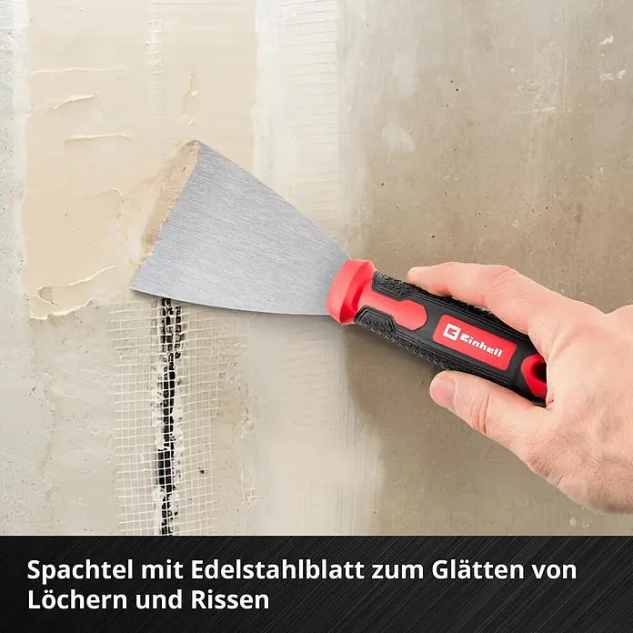 Einhell Werkzeugkoffer E-Case Renovierung - 78 -tlg. - Spachtel mit Edelstahlblatt und rot-schwarzem Griff, wird von einer Hand zum Glätten von Löchern und Rissen auf einer Wand verwendet.
